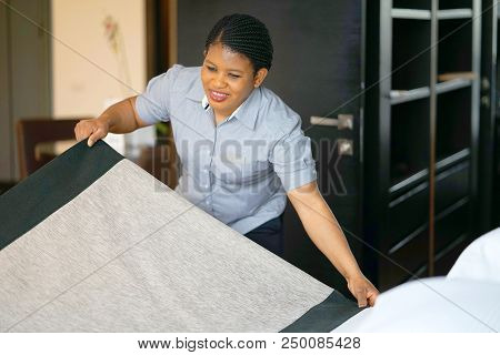 Maid Making Bed In Hotel Room. Staff Maid Making Bed. African Housekeeper Making Bed.