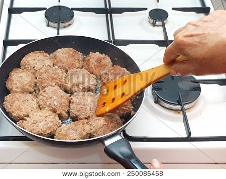Closeup Opf Female Hand Cooking Cutlets On The Frying Pan