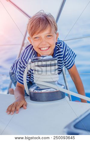 Cute Boy On Board Of Sailing Yacht On Summer Cruise. Travel Adventure, Yachting With Child On Family