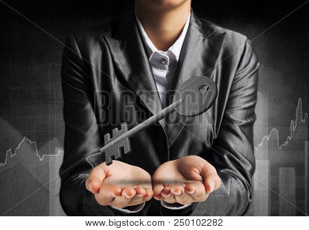 Cropped Image Of Businessman In Suit Keeping Stone Key Symbol In Hands With Business Sketches On Dar