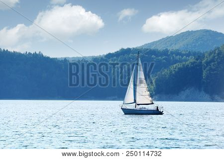 White yacht on Solina lake, Poland. Landscape photography