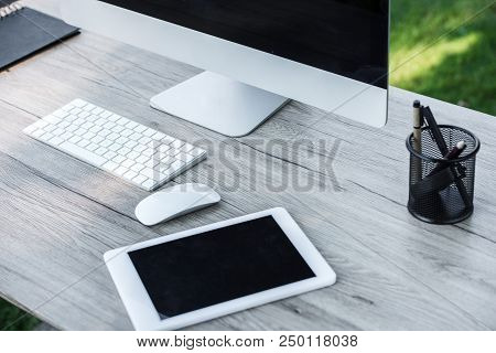 Selective Focus Of Digital Tablet And Computer With Blank Screens At Table Outdoors