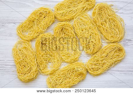 Uncooked Pasta Tagliolini On White Wooden Backgroundm Top View. Flat Lay, Overhead.