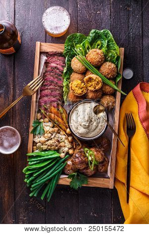 Meze Dishes On A Dark Background. Meat, Falafel, Baba Ghanoush, Vegetables. Halal Food. Space For Te