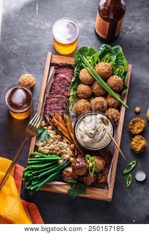 Middle Eastern Or Arabic Dishes And Assorted Meze On A Dark Background. Meat, Falafel, Baba Ghanoush