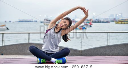 Sports Concept. Beautiful Girl Is Exercising On The Beach With Warm Up. Beautiful Girl Is Happy To E