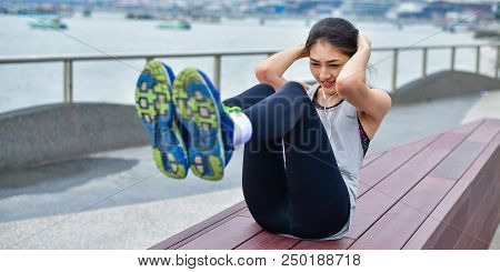 Sports Concept. Beautiful Girl Is Exercising On The Beach With Warm Up. Beautiful Girl Is Happy To E
