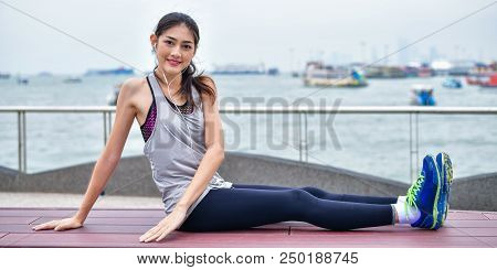 Sports Concept. Beautiful Girl Is Exercising On The Beach With Warm Up. Beautiful Girl Is Happy To E