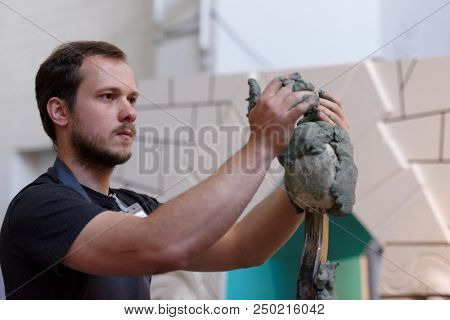 ST. PETERSBURG, RUSSIA - JULY 15, 2018: Sculptor Danila Reshetov participates in artistic battle during the opening of festival Laboratory Of Sculpture in the museum workshop of sculptor M. Anikushin