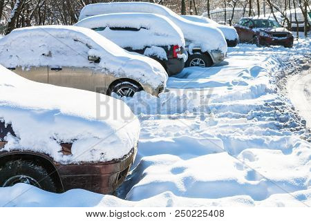 Snow-covered Cars On Car Parking In Moscow City In Sunny Winter Day