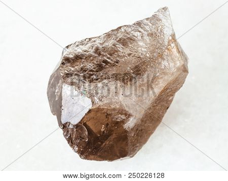Macro Shooting Of Natural Mineral - Rough Smoky Quartz Crystal On White Marble From Ural Mountains