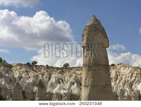 Rural Landscape In The Valley Of Love, Cappadocia. Large Phallic Rock Formations Against The Blue Su
