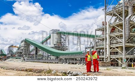Conveyor Belt Transporting Platinum Ore For Processing With Mining Safety Inspectors Checking For Da