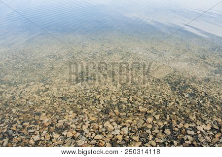 Stony Shore Of The Lake With Clear And Transparent Water