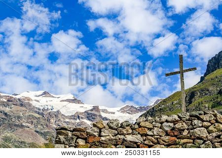 Wooden Cross In An Alpine Valley