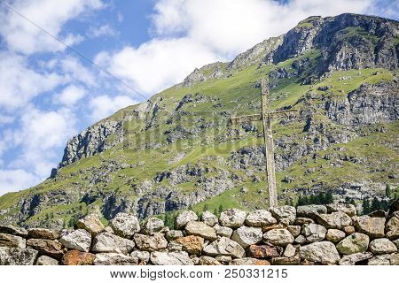 Wooden Cross In An Alpine Valley