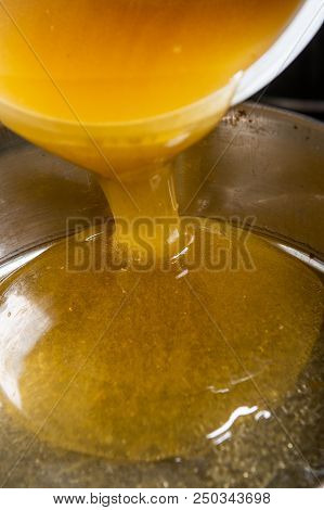 Strain The Poured Honey Through A Sieve. How To Harvest Honey. Filtering Raw Honey.