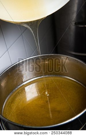 Strain The Poured Honey Through A Sieve. How To Harvest Honey. Filtering Raw Honey.