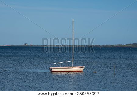 Small Sailboat In The Water Near The Coast Of Denmark On A Summer Day