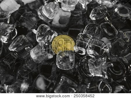 Gold Ripple Coin On Ice Background. The Concept Of The Exchange In Winter. Freeze. Blockchain Mining