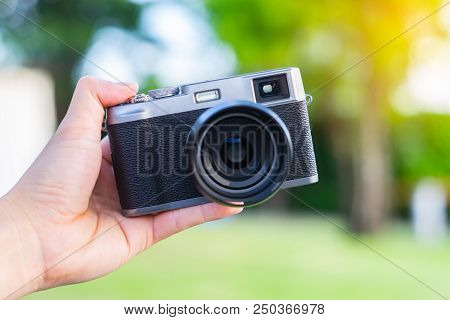 Soft Focus Photo Of Retro-style Rangefinder Camera. Black-and-gray Camera On Hand. 

Old Camera,anci