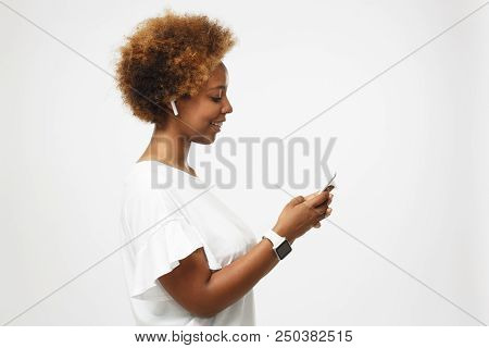 Side Portrait Of Young African American Woman In White T Shirt, Isolated On Gray Background, Looking