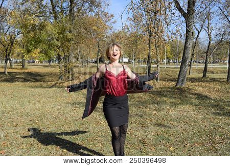 A Woman Is Posing In Front Of A Camera In An Autumn Park. Autumn Photo Shoot. Autumn In The Park.