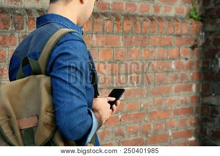 Latin Man Typing On His Phone.