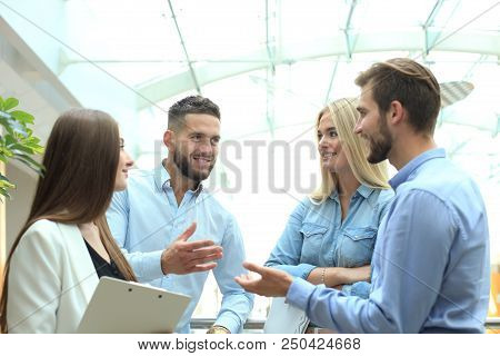 Young Modern Colleagues In Smart Casual Wear Having A Brainstorm Meeting While Standing In The Creat