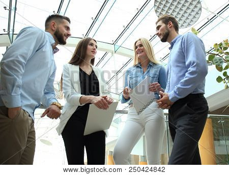 Young Modern Colleagues In Smart Casual Wear Having A Brainstorm Meeting While Standing In The Creat
