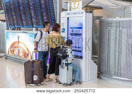 Bangkok, Thailand - 21 July 2018 - An Asian Family Checks Out Their Airline Information Through A Ki