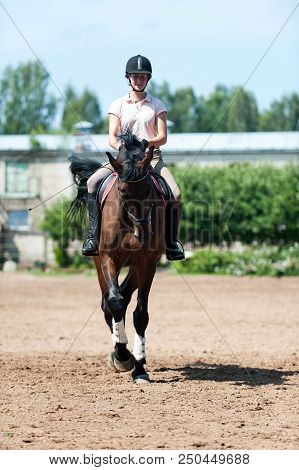 Teenage Girl Equestrian Riding Horseback On Arena At Sport Training. Vibrant Multicolored Outdoors V