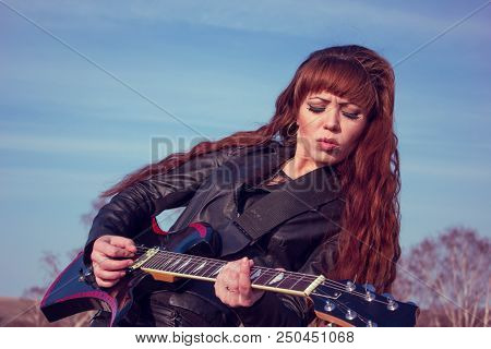 Beautiful Girl In Leather Jacket With Guitar
