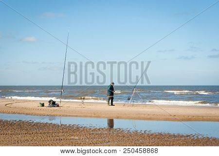 Egmond-aan-zee, Netherlands - 2016-04-10: One Fisher Man With Two Fishing Rods On The North Sea Beac