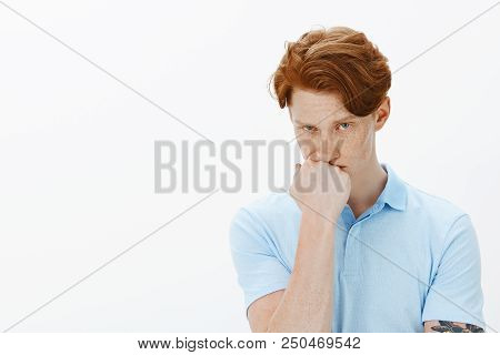Indoor Shot Of Pissed Offended Attractive Guy With Freckles And Red Hair, Leaning Head On Fist And L
