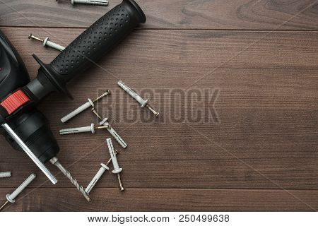 Hammer Drill And Dowels On The Wooden Background With Copy Space