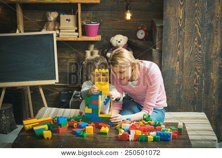 Building Concept. Mother And Son Play With Building Blocks. Mother And Child Build Structure With To