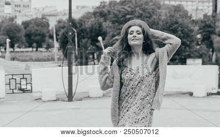 A Beautiful Girl In A Hat, Keeps The Hair From The Wind. Sits On Scraps. Walk Around The City. Portr