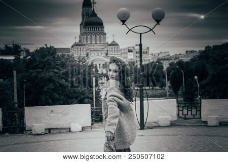 A Beautiful Girl In A Hat, Keeps The Hair From The Wind. Sits On Scraps. Walk Around The City. Portr