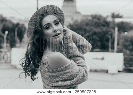 A Beautiful Girl In A Hat, Keeps The Hair From The Wind. Sits On Scraps. Walk Around The City. Portr