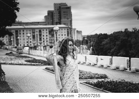 A Beautiful Girl In A Hat, Keeps The Hair From The Wind. Sits On Scraps. Walk Around The City. Portr