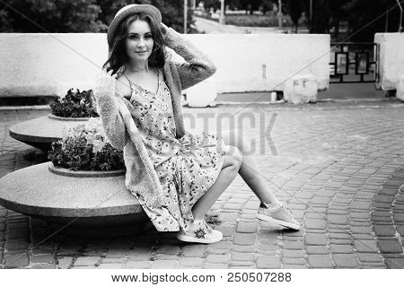 A Beautiful Girl In A Hat, Keeps The Hair From The Wind. Sits On Scraps. Walk Around The City. Portr