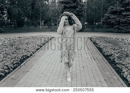 A Beautiful Girl In A Hat, Keeps The Hair From The Wind. Sits On Scraps. Walk Around The City. Portr
