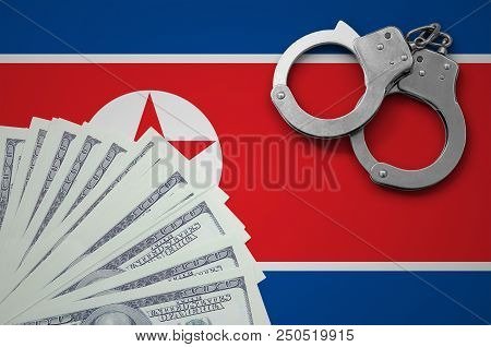 North Korea Flag  With Handcuffs And A Bundle Of Dollars. The Concept Of Illegal Banking Operations 