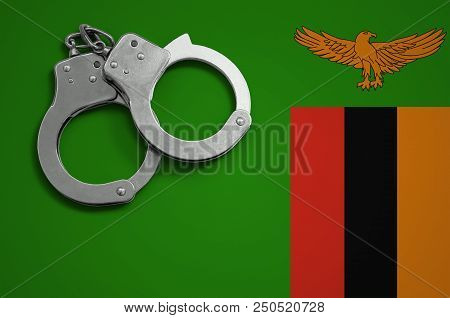 Zambia Flag  And Police Handcuffs. The Concept Of Crime And Offenses In The Country.