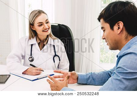 Doctor Discussing And Consulting With Male Patien On Doctors Table In Hospital.healthcare And Medici