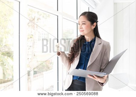 Close Up Beauty Asian Business Woman Hoding A Cup Of Coffee Near Window For Relaxation Time And Happ