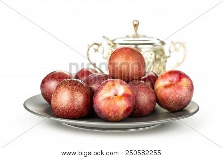 Lot Of Whole Fresh Pluot Interspecific Plums Variety On A Ceramic Grey Plate With A Sugar Bowl Still