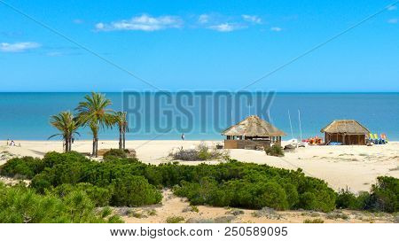 Two Huts Staying On The White Sandy Beach Where Surfers Keep Their Equipment