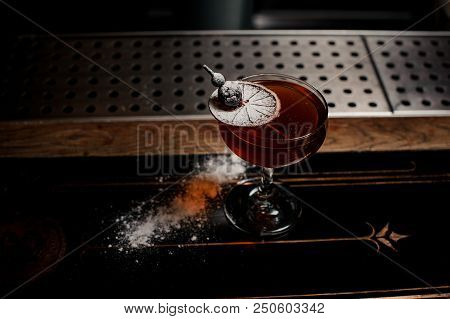 Cocktail With The Dried Orange On The Skewer Decorated With Powdered Sugar Standing On The Bar Count